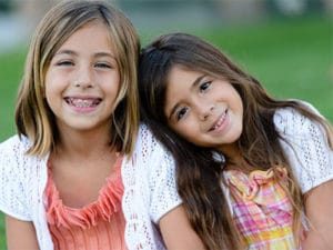 young girl with braces and her younger sister