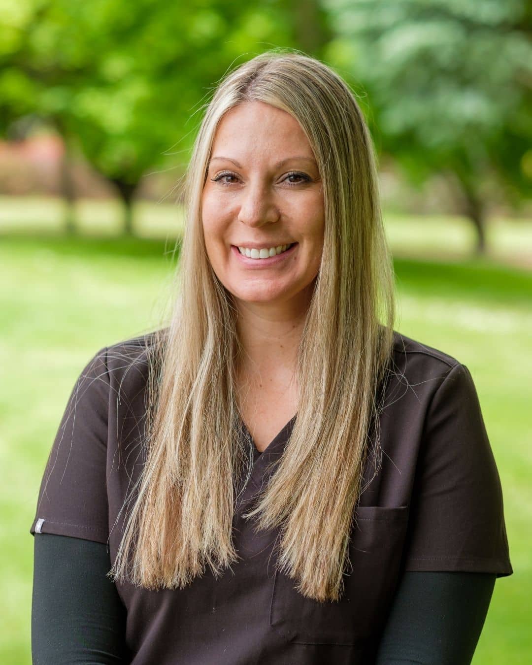 Portrait of Amanda, orthodontic assistant, smiling outdoors in black scrubs, Dr. W. Gray Grieve Orthodontics, Eugene, OR