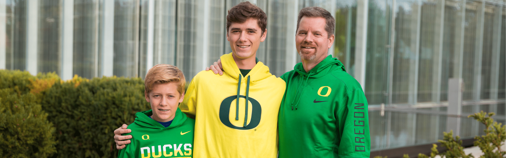 Father and two children wearing Oregon Ducks hoodies while standing together outdoors, Dr. W. Gray Grieve Orthodontics, Eugene, OR