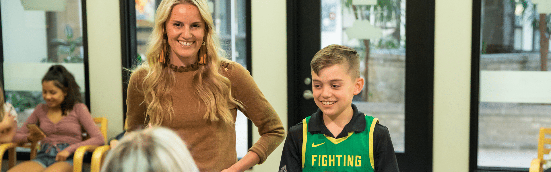 Smiling staff member and child patient standing together inside the orthodontic office, Dr. W. Gray Grieve Orthodontics, Eugene, OR